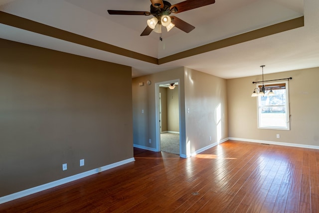 spare room featuring ceiling fan with notable chandelier and wood-type flooring