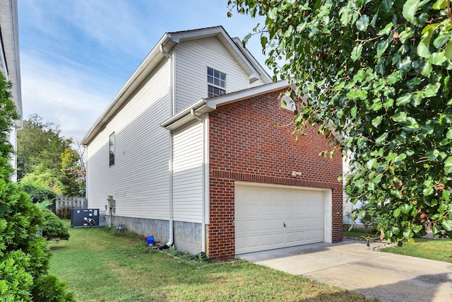 view of home's exterior with a garage, central AC unit, and a yard