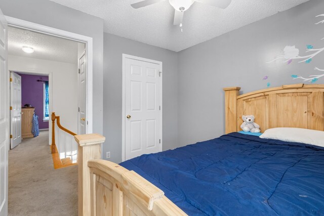 carpeted bedroom featuring a textured ceiling and ceiling fan