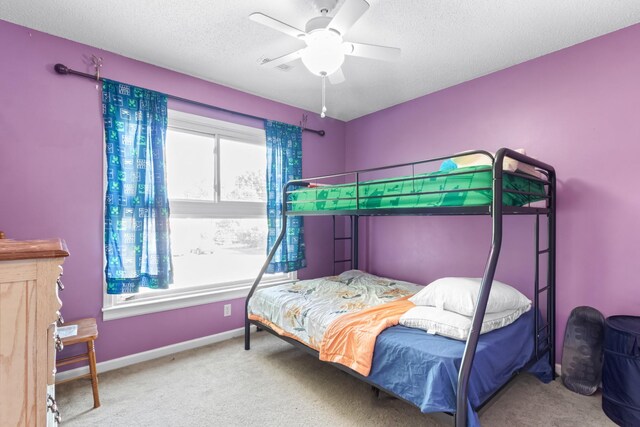 carpeted bedroom featuring a textured ceiling and ceiling fan