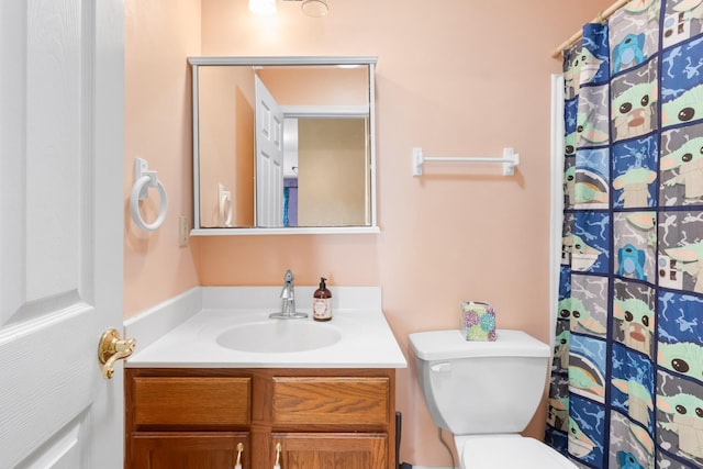 bathroom featuring a shower with shower curtain, toilet, and vanity