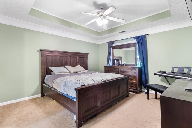 bedroom with a tray ceiling, light colored carpet, ornamental molding, and ceiling fan