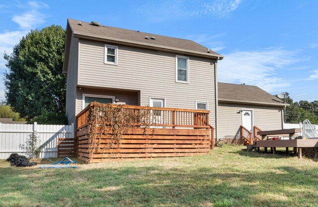 back of property with a yard and a wooden deck