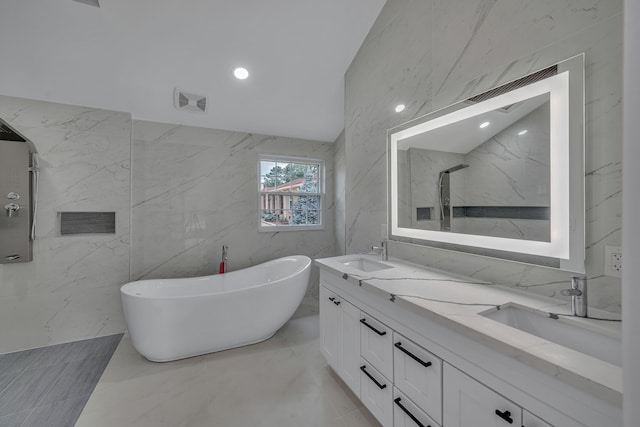 bathroom featuring a tub to relax in, tile walls, vanity, and vaulted ceiling