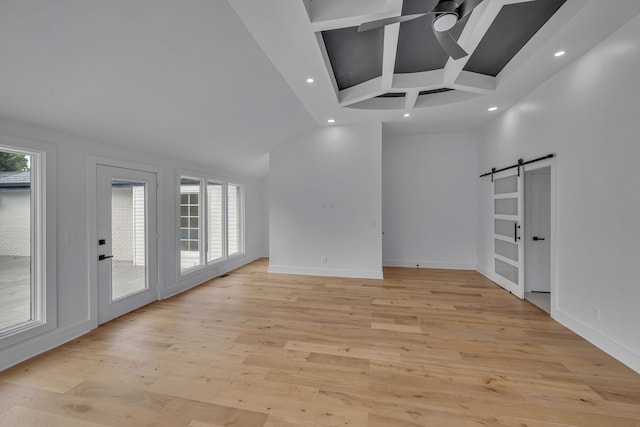 unfurnished room featuring a barn door, coffered ceiling, ceiling fan, and light hardwood / wood-style flooring