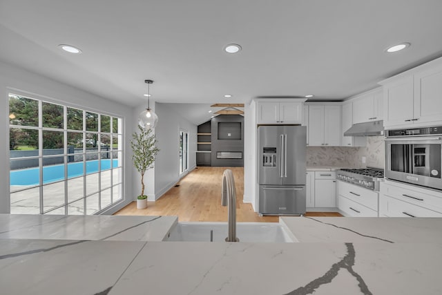 kitchen featuring light stone counters, appliances with stainless steel finishes, light wood-type flooring, and white cabinetry