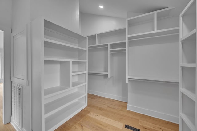 walk in closet with light hardwood / wood-style floors