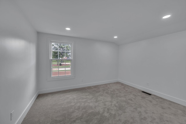 unfurnished room featuring light carpet