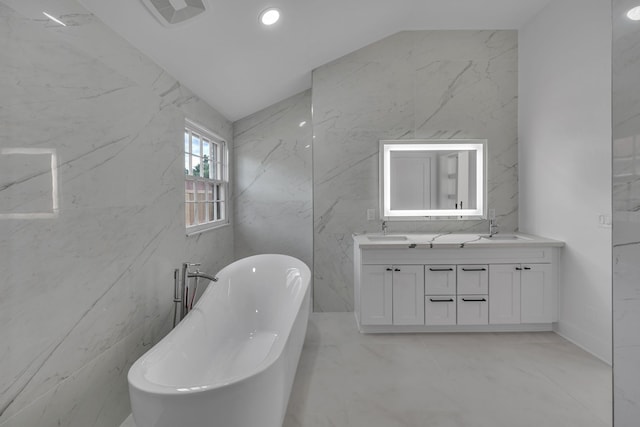 bathroom with vaulted ceiling, a tub, and vanity