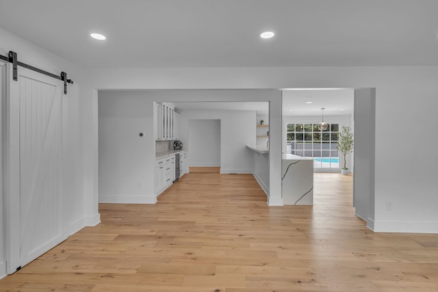 interior space with a barn door and light hardwood / wood-style floors