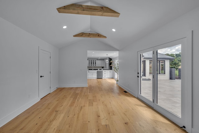 interior space with vaulted ceiling with beams and light hardwood / wood-style floors