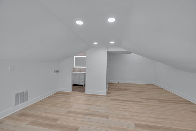 bonus room featuring sink, lofted ceiling, and light hardwood / wood-style floors