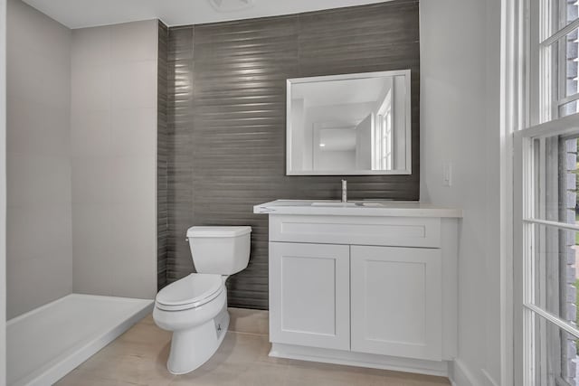 bathroom featuring vanity, a shower, toilet, and tile patterned floors