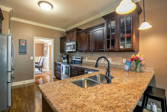 kitchen with crown molding, stainless steel appliances, kitchen peninsula, sink, and dark hardwood / wood-style floors