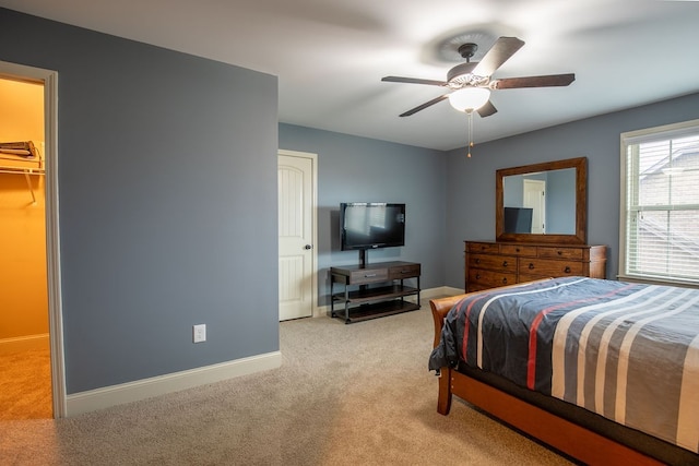 carpeted bedroom featuring a closet, ceiling fan, and a spacious closet