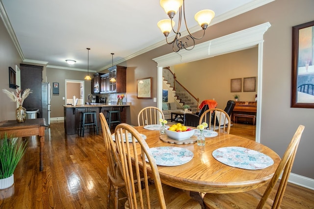 dining space featuring crown molding, a notable chandelier, and dark hardwood / wood-style floors