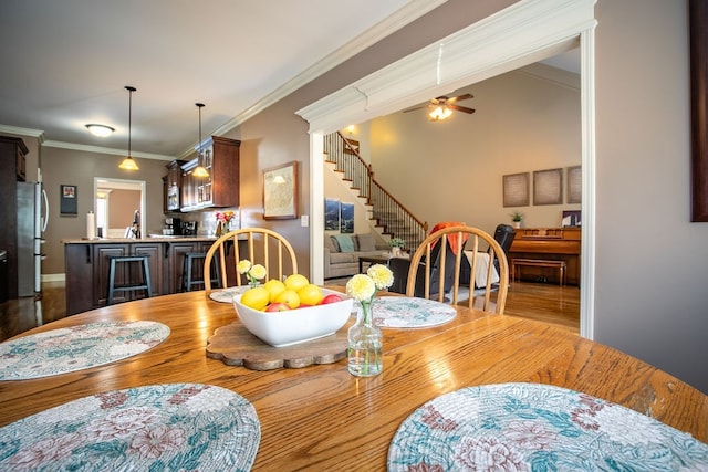 dining space featuring crown molding, hardwood / wood-style flooring, and ceiling fan