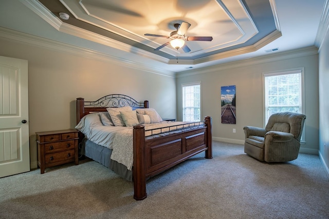 carpeted bedroom with ceiling fan, a raised ceiling, and ornamental molding