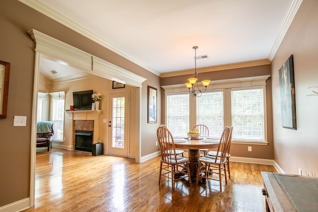 dining space with ornamental molding, light hardwood / wood-style flooring, and a notable chandelier