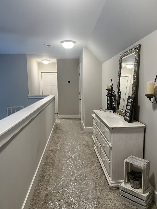 hallway with vaulted ceiling and carpet floors