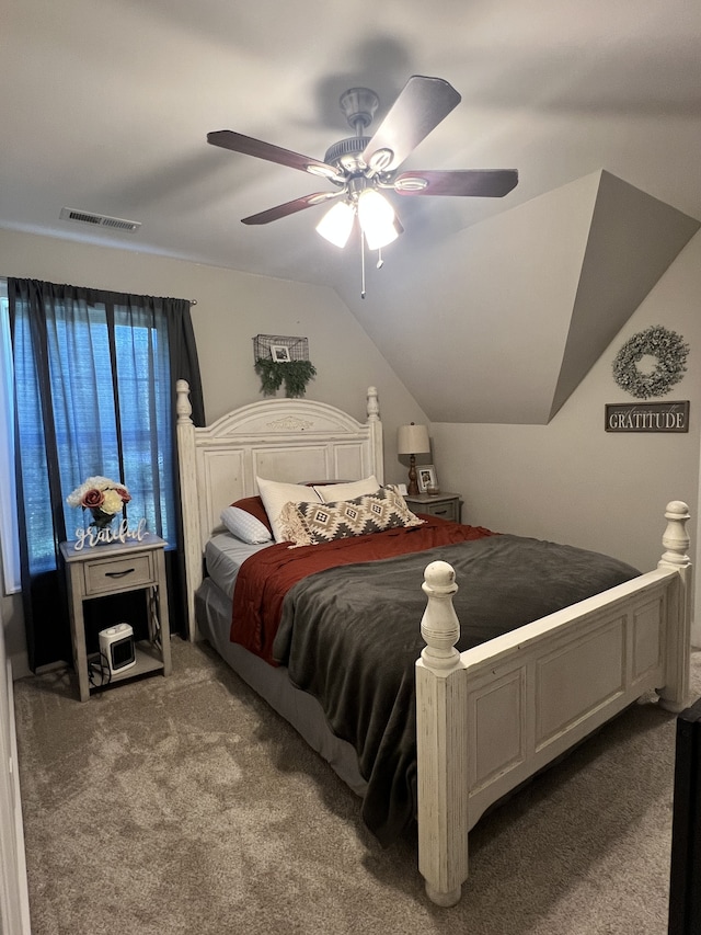 bedroom with ceiling fan, lofted ceiling, and carpet flooring