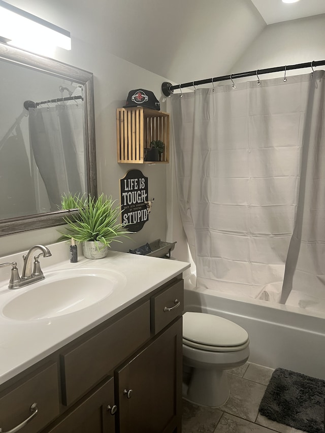 full bathroom featuring tile patterned flooring, vaulted ceiling, shower / bath combo with shower curtain, vanity, and toilet