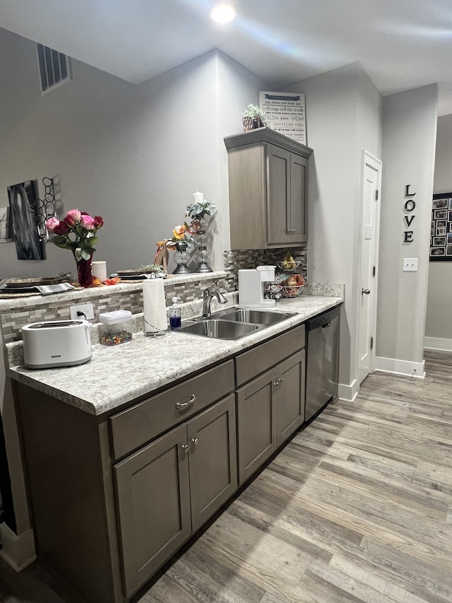 kitchen featuring light hardwood / wood-style flooring, dishwasher, backsplash, and sink