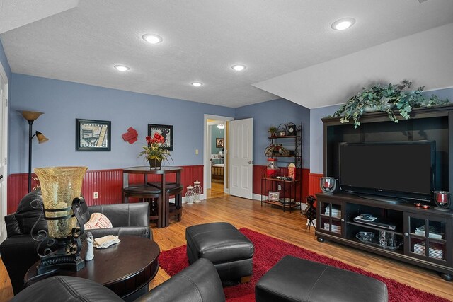 living room featuring a textured ceiling and wood-type flooring