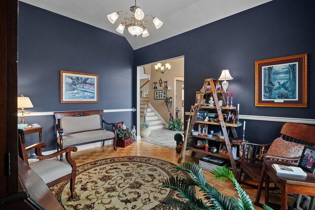 sitting room with vaulted ceiling and a notable chandelier