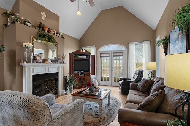 living room with light wood-type flooring, french doors, high vaulted ceiling, and ceiling fan