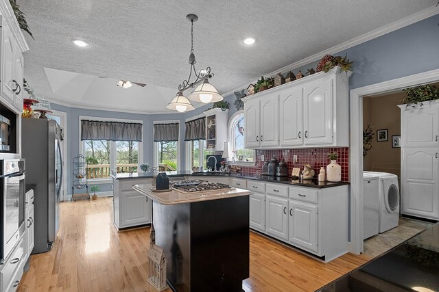 kitchen featuring a center island, light hardwood / wood-style floors, ornamental molding, and separate washer and dryer