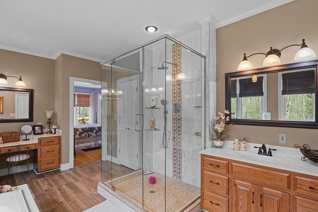 bathroom featuring a shower with shower door, wood-type flooring, ornamental molding, and vanity