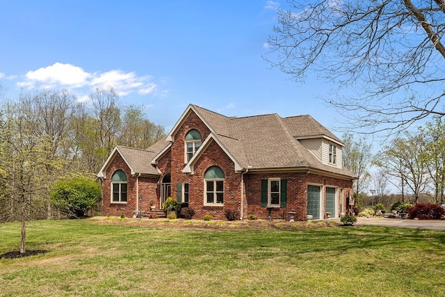 view of front of property with a front yard, brick siding, driveway, and roof with shingles