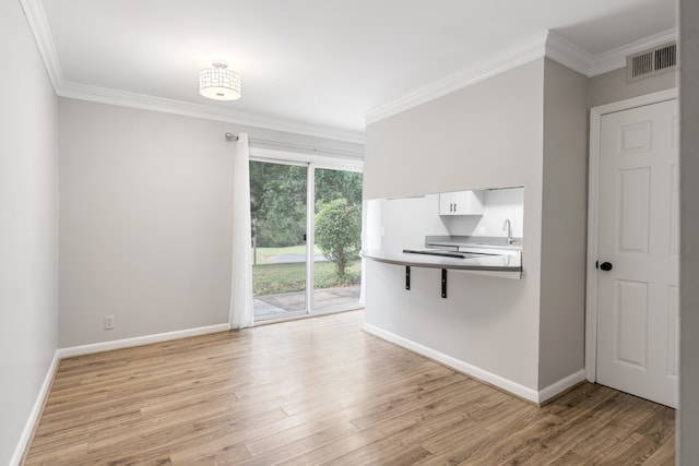 spare room featuring ornamental molding and light wood-type flooring