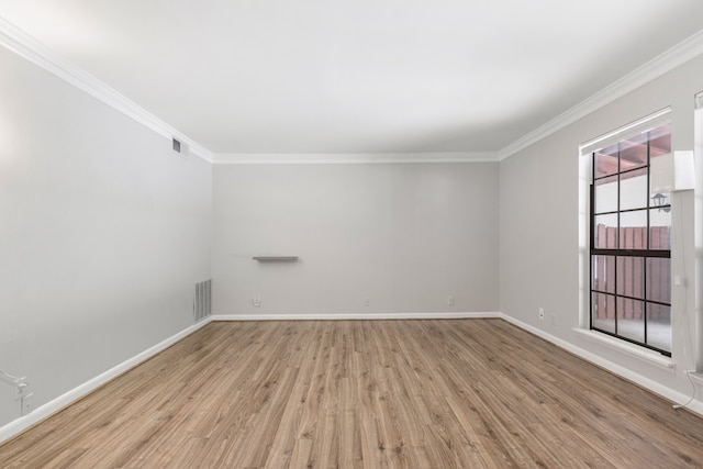 unfurnished room featuring ornamental molding and light wood-type flooring