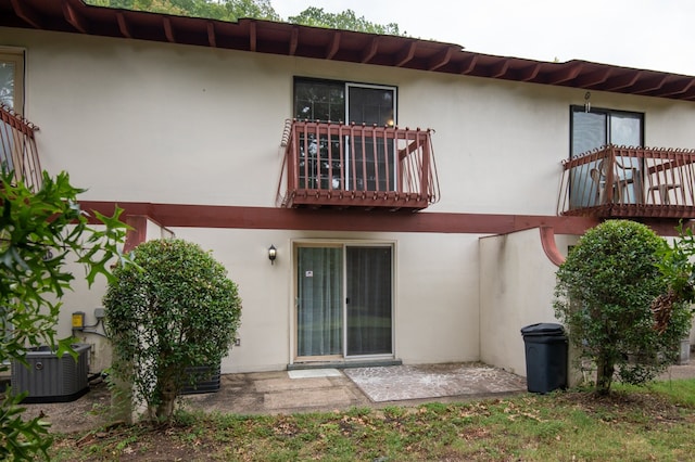 back of house with central AC unit and a balcony