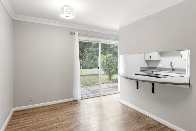 kitchen with white cabinets, a breakfast bar area, sink, and a healthy amount of sunlight