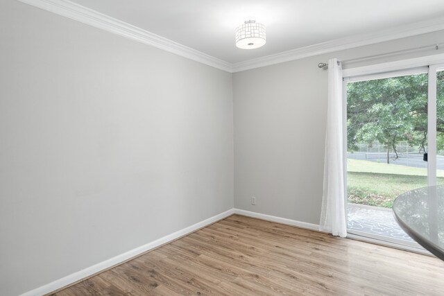 spare room featuring a healthy amount of sunlight, ornamental molding, and light wood-type flooring