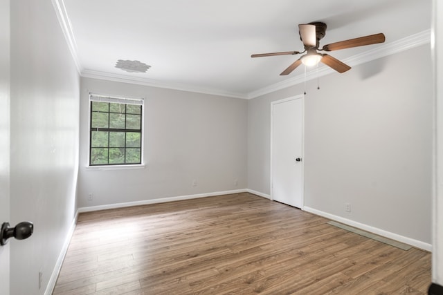 spare room featuring crown molding, ceiling fan, and light wood-type flooring