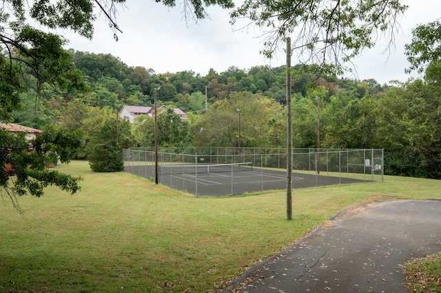 view of sport court featuring a lawn