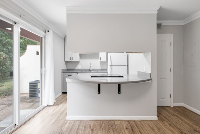 kitchen featuring white cabinets, light wood-type flooring, appliances with stainless steel finishes, a breakfast bar area, and ornamental molding