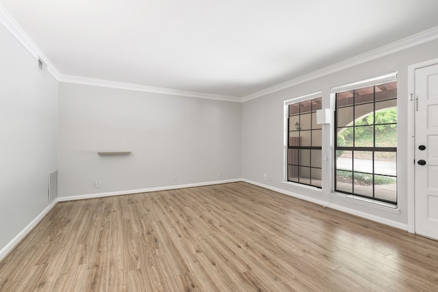 empty room featuring light wood-type flooring and ornamental molding