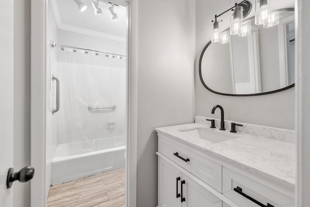 bathroom featuring vanity, ornamental molding, hardwood / wood-style floors, and bathing tub / shower combination