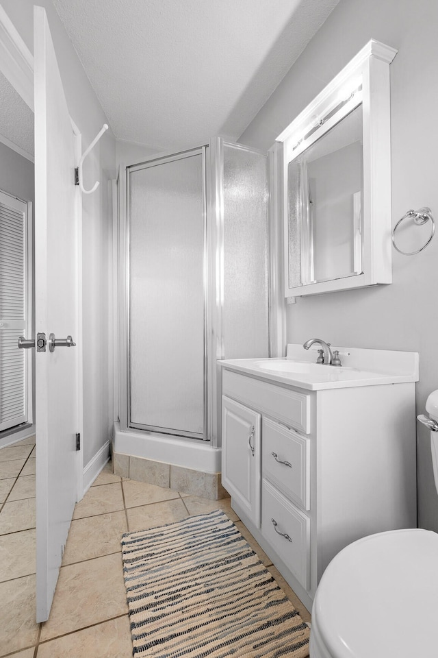 bathroom with an enclosed shower, tile patterned floors, toilet, vanity, and a textured ceiling