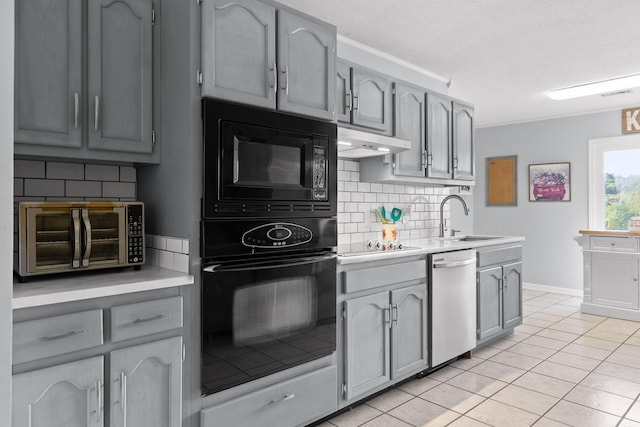 kitchen featuring gray cabinets, black appliances, light tile patterned flooring, and sink