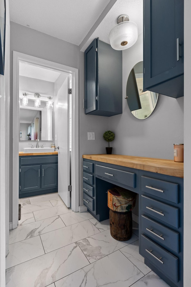 bathroom featuring a textured ceiling and vanity