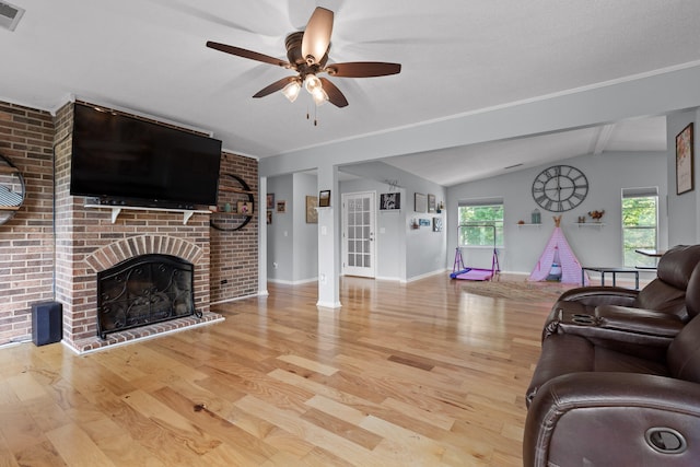 living room with a fireplace, lofted ceiling, light hardwood / wood-style flooring, and ceiling fan