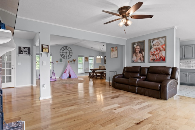 living room featuring a textured ceiling, sink, ceiling fan, vaulted ceiling, and light hardwood / wood-style floors