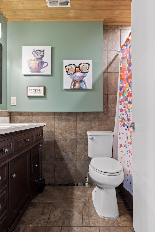 bathroom with vanity, wooden ceiling, walk in shower, tile walls, and toilet