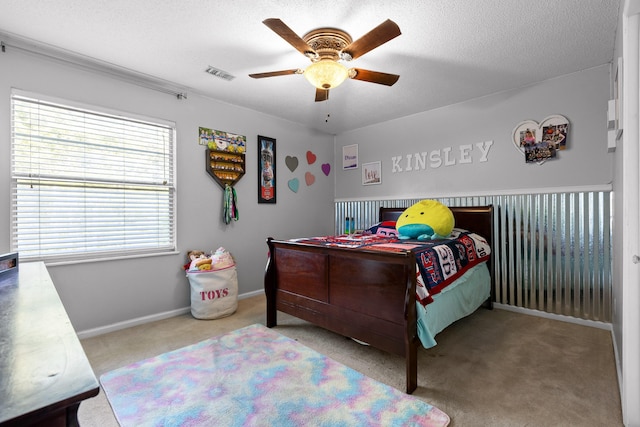 carpeted bedroom featuring a textured ceiling and ceiling fan